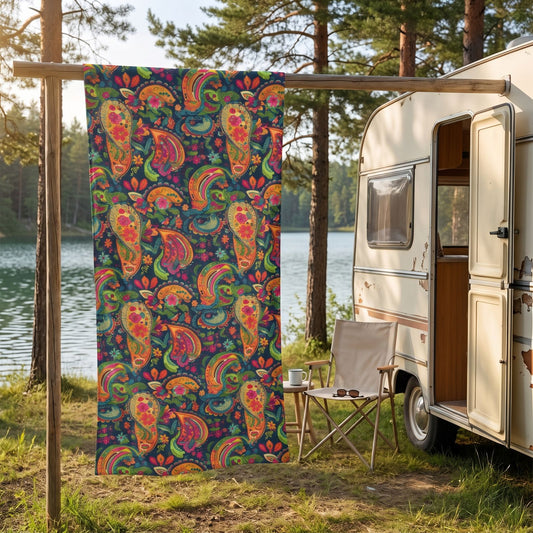 Psychedelic Paisley Party beach towel, displayed in a summer setting.