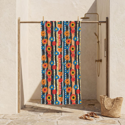 Striped Daisy Play beach towel, displayed in a summer setting.