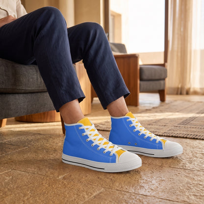 Bold & Gold Men's Two-Tone High Top Sneakers. Lifestyle scene: Desert hotel lounge; caramel stone, charcoal chair, soft golden-hour window light