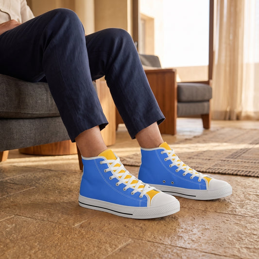 Bold & Gold Men's Two-Tone High Top Sneakers. Lifestyle scene: Desert hotel lounge; caramel stone, charcoal chair, soft golden-hour window light