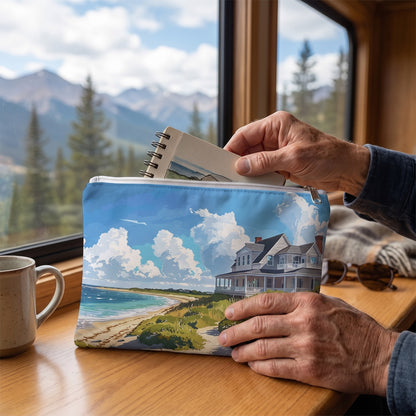 Large Nantucket Beach House accessory pouch (11.81 × 8.35 inches) in use: man retrieves a travel sketchbook from pouch, window mountains blurred. Lifestyle mockup with hands showing scale.