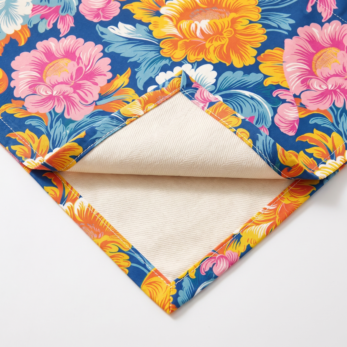 Close-up of Chintz Charm napkin corner folded back showing cream twill backside and hem