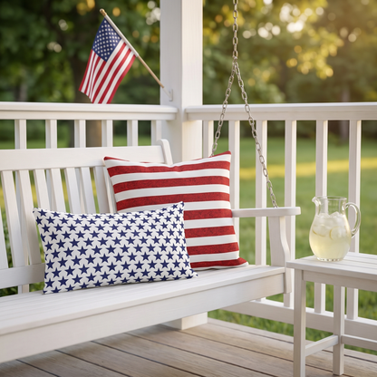 Starry Salute outdoor lumbar pillow with Sparkle Stripes square on a porch swing with an American flag