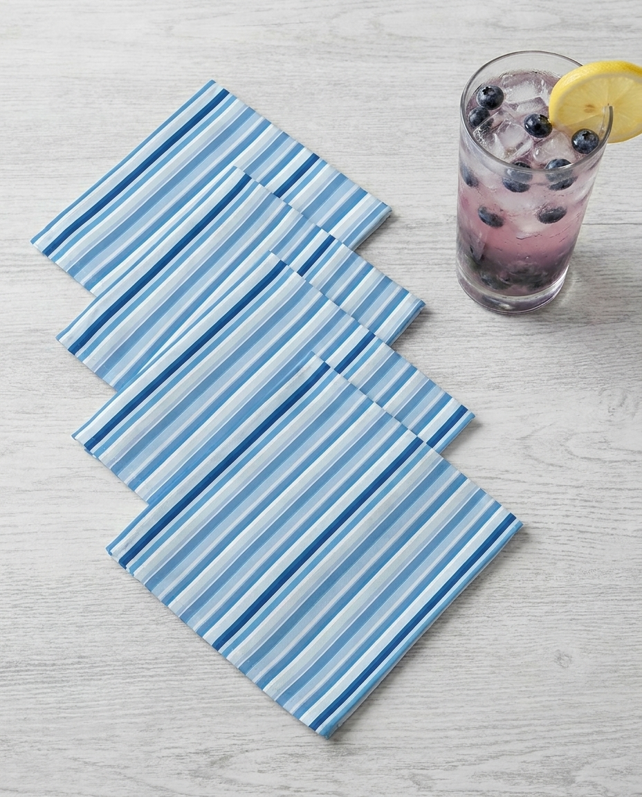 Shades of Light Blue Stripes cocktail napkins, set of four, with drink for scale